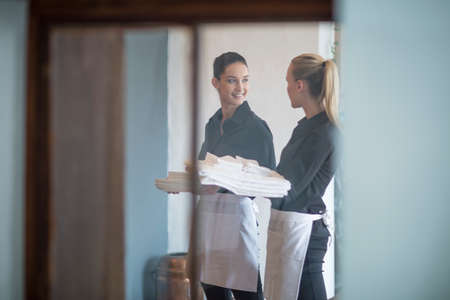 Waitresses chatting whilst workingの写真素材