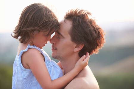 Portrait of man and daughter face to face with eyes closed, Buonconvento, Tuscany, Italy