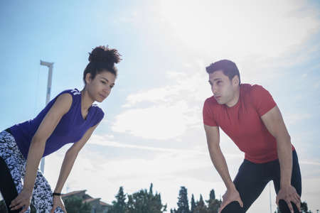 Young man and woman training, taking a break at sport facilityの写真素材