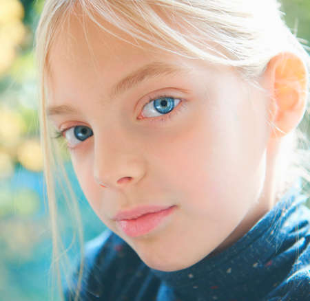 Close up portrait of blond blue eyed girl in gardenの写真素材