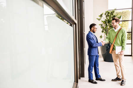 Two businessmen shaking hands outside office building