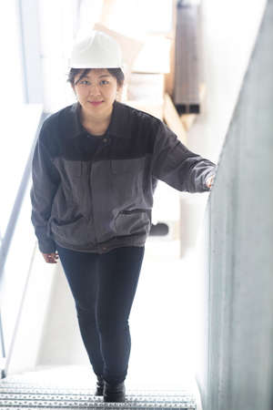 Worker walking up staircase in factory