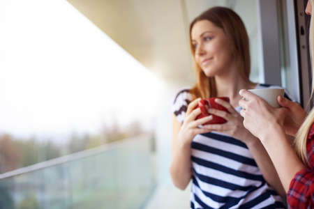 Two female friends, drinking coffee, outdoorsの写真素材