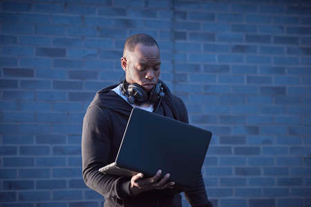 Man with headphones holding laptopの写真素材