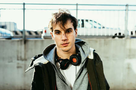 Portrait of man wearing hooded top and head phones looking at cameraの写真素材