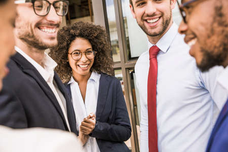 Businessmen and businesswomen talking outside office