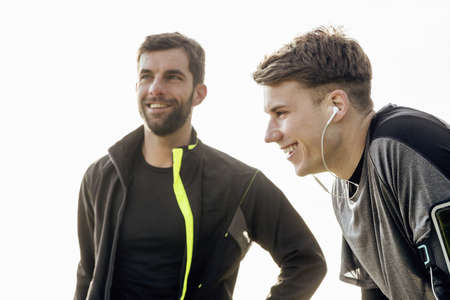 Two male friends exercising outdoorsの写真素材