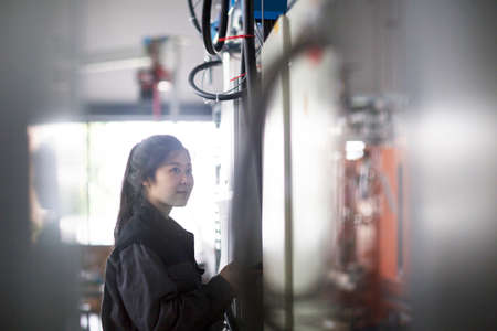 Technician operating machine in factoryの写真素材