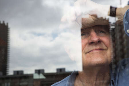 Man smiling and leaning head against window
