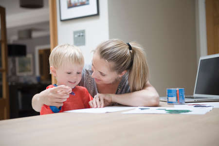 Mother helping son to write