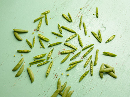 Overhead view of peas in pea pods on green backgroundの写真素材