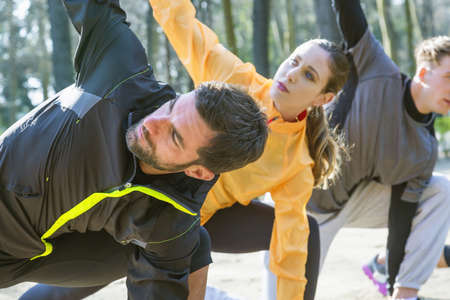 Group of friends exercising outdoors, stretching