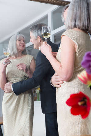Couple dressed up and having drink in front of mirrorの写真素材