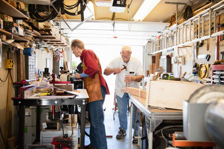 Senior men working with hammer in carpentry workshopの写真素材
