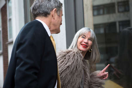 Couple dressed up and interested in shop windowの写真素材