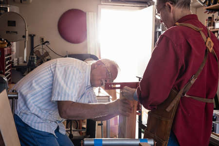 Senior men checking spirit level in carpentry workshopの写真素材