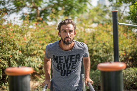 Young man training on park exercise equipment, Dubai, United Arab Emiratesの写真素材