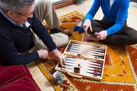 Couple playing backgammon on floorの写真素材