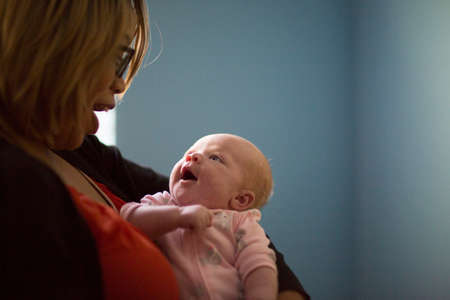 Young woman and baby daughter smiling at each other