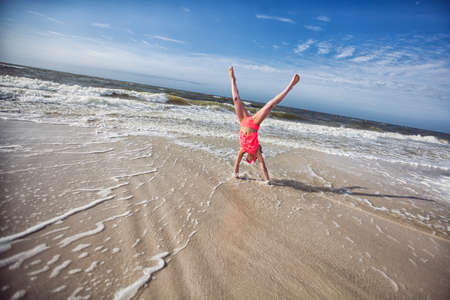 Girl doing handstand on beachの写真素材