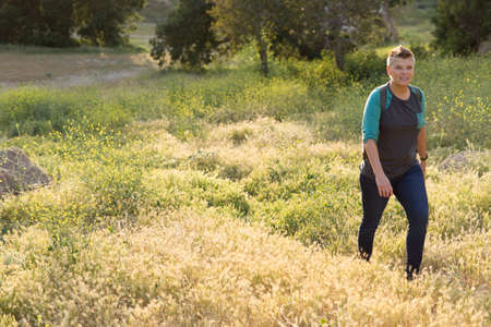 Woman hiker walking up hill