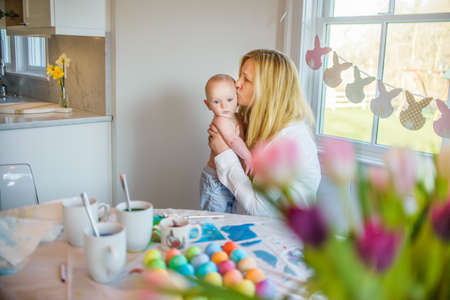 Mother at dining table kissing son on foreheadの写真素材