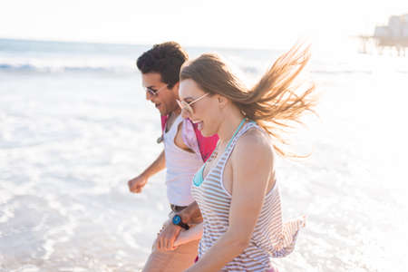 Young couple paddling in sea, Santa Monica, California, USA