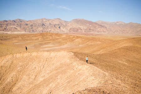 Man and boy exploring rim in desert, Olancha, California, USA