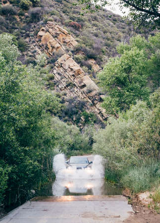 Off road vehicle driving through deep water on rural road, Santa Barbara, California, USAの写真素材