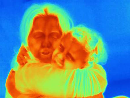 Thermal image of mature woman and son hugging each otherの写真素材