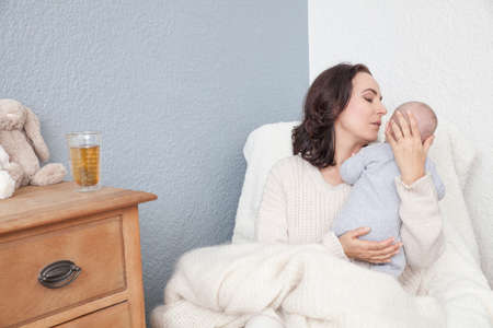 Mother sitting in chair with baby boyの写真素材