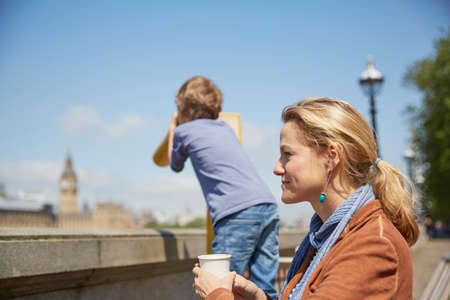 Mother and son using coin operated binoculars