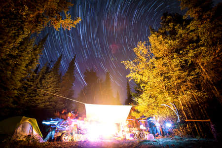 Long exposure of stars in night sky and light trails around campfire, Elinor Lake Recreational Area, Naramata, British Columbia, Canadaの写真素材