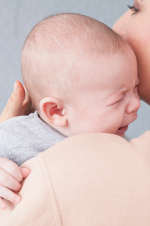 Mother comforting baby boy, close-up