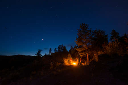 Friends round campfire, Pincushion Mountain, Peachland, British Columbia, Canada