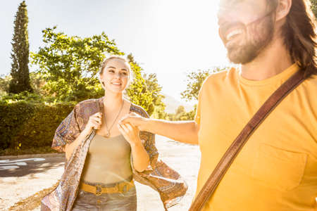 Young couple holding hands strolling along road, Franschhoek, South Africa