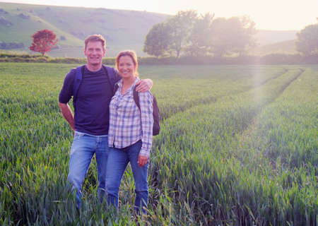 Couple in field looking at camera smilingの写真素材