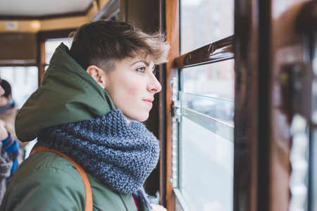 Young woman looking out of cable car windowの写真素材