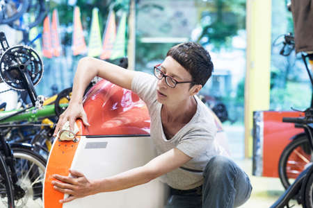 Woman in workshop checking recumbent bicycle bodyworkの写真素材