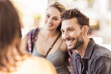 Friends in street chatting and smilingの写真素材