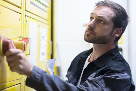 Man adjusting leaver on control panelの写真素材