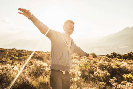 Man in field, arms open smilingの写真素材