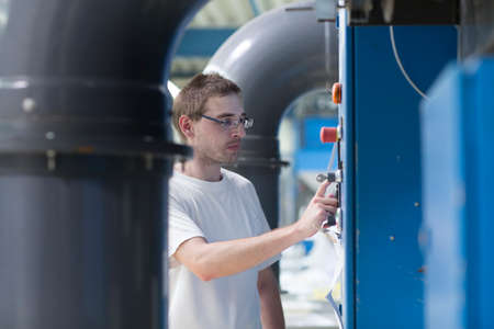 Man adjusting control panelの写真素材