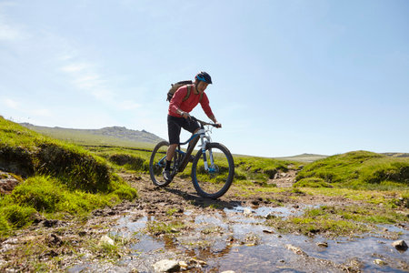 Cyclists cycling through waterの写真素材