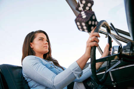 Low angle view of woman driving convertible car, Los Angeles, California, USA