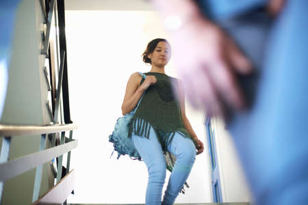 Young female college student moving down stairway