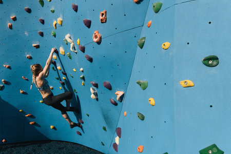 Young woman on climbing wall, Brooklyn Bridge Park, Brooklyn, New York, USA
