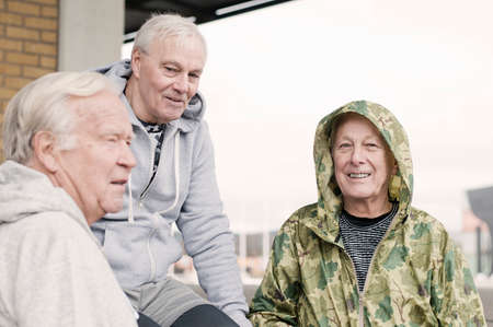 Senior friends wearing sports clothes sitting together