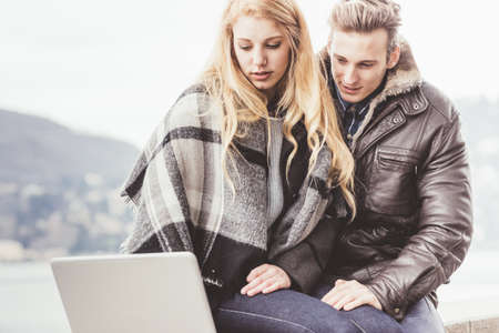 Young couple using laptop, Lake Como, Italyの写真素材