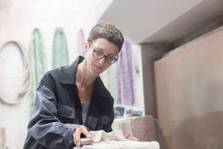 Stonemason sanding stone with sanding blockの写真素材